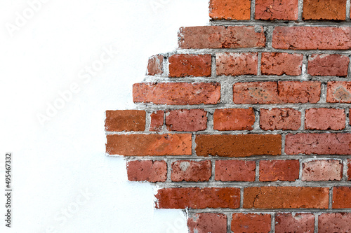 Decorative masonry made of red clay bricks. The texture of natural stone on the background of white plaster.