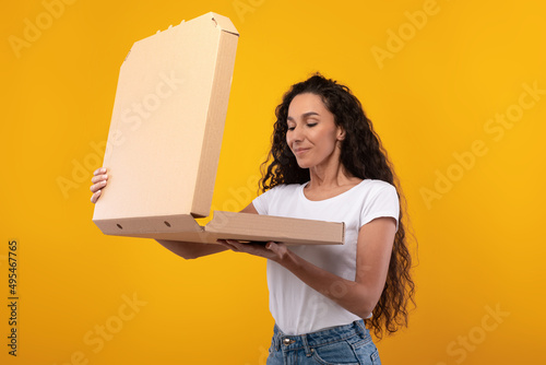 Young Lady Holding Box Looking At Pizza At Studio