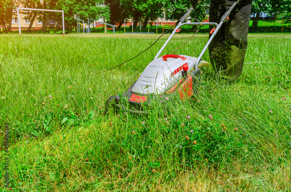 Fototapeta premium Manual lawn mower on a football field. Mowing the grass.