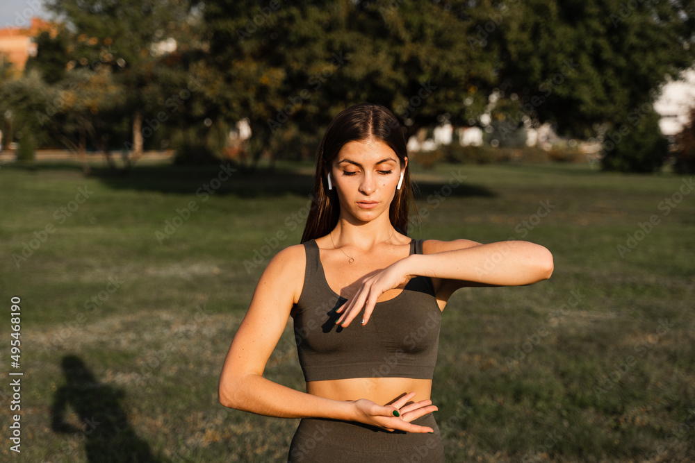 Hand movement of qigong meditation. Attractive girl meditating in the green park. Hand movement of qigong meditation. Attractive girl meditating in the green park.