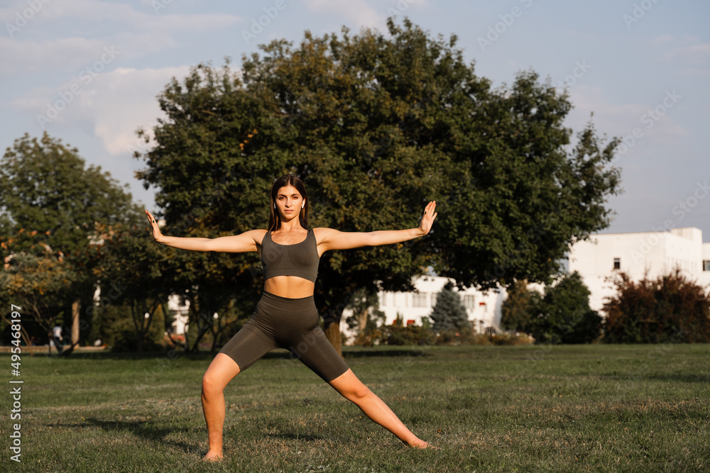 Hand movement of qigong meditation. Attractive girl meditating in the green park. Hand movement of qigong meditation. Attractive girl meditating in the green park.