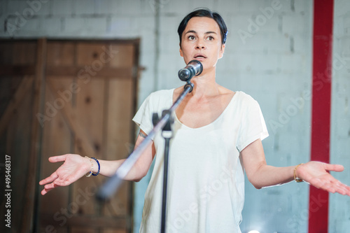 Fotografia Smiling and witty stand up actor comedian on stage, talking and singing