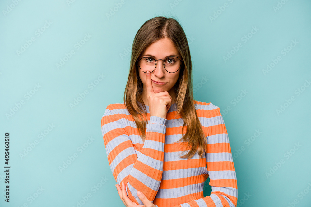 Young caucasian woman isolated on blue background unhappy looking in camera with sarcastic expression. Young caucasian woman isolated on blue background unhappy looking in camera with sarcastic expression.
