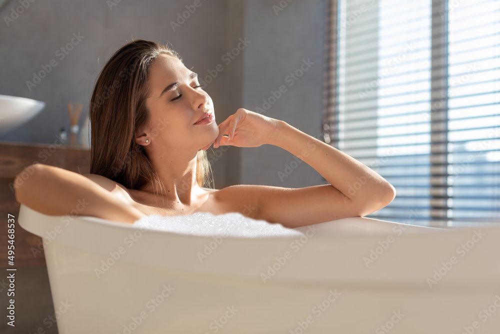 Closeup Shot Of Attractive Young Female Sitting In Bathtub Filled With Foam Closeup Shot Of Attractive Young Female Sitting In Bathtub Filled With Foam
