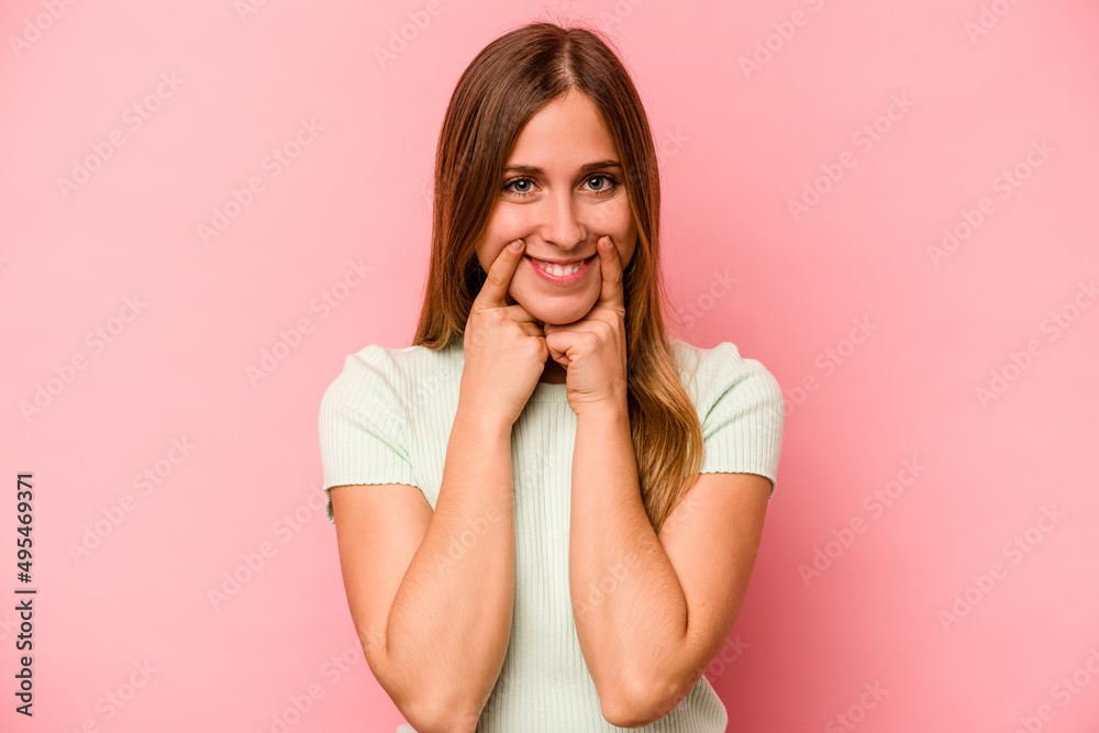 Young caucasian woman isolated on pink background doubting between two options. Young caucasian woman isolated on pink background doubting between two options.