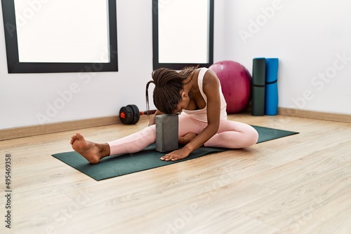 Young african american woman stretching at sport center