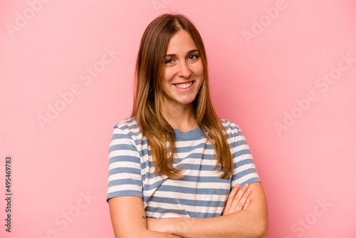 Young caucasian woman isolated on pink background who feels confident  crossing arms with determination.