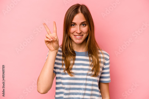 Young caucasian woman isolated on pink background showing number two with fingers.