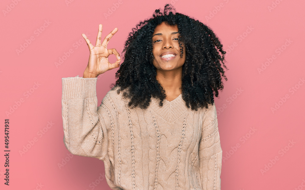 Young african american girl wearing casual clothes smiling positive doing ok sign with hand and fingers. successful expression. Young african american girl wearing casual clothes smiling positive doing ok sign with hand and fingers. successful expression.
