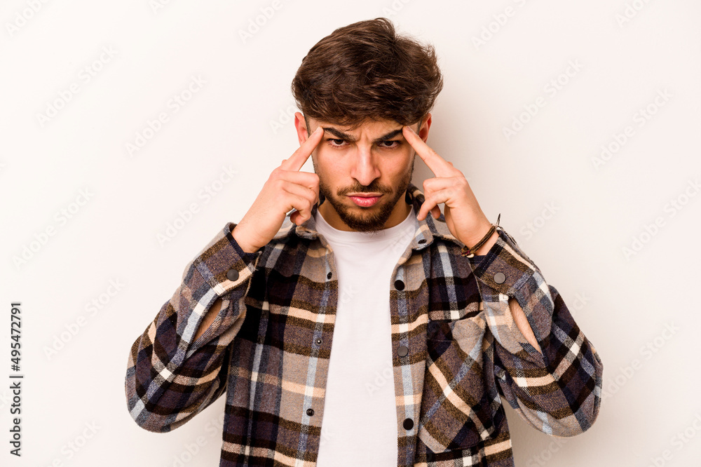 Young hispanic man isolated on white background focused on a task, keeping forefingers pointing head. Young hispanic man isolated on white background focused on a task, keeping forefingers pointing head.