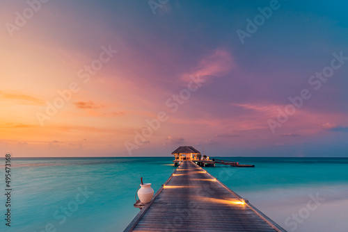 Fototapeta Naklejka Na Ścianę i Meble -  Amazing sunset island landscape at Maldives. Luxury resort water villas jetty. Beautiful beach seascape with soft led lights colorful sky background for vacation holiday. Panoramic tropical paradise