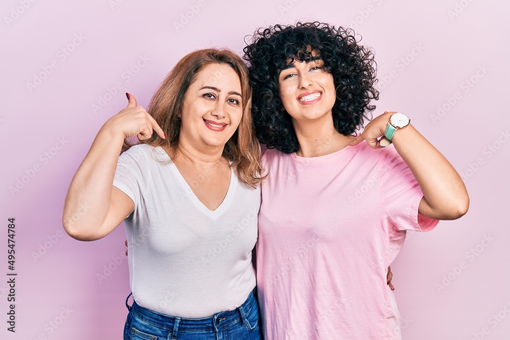 Middle east mother and daughter wearing casual clothes looking confident with smile on face, pointing oneself with fingers proud and happy. Middle east mother and daughter wearing casual clothes looking confident with smile on face, pointing oneself with fingers proud and happy.