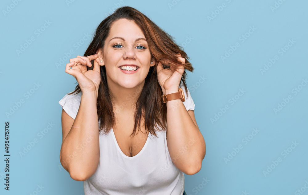 Young plus size woman wearing casual white t shirt smiling pulling ears with fingers, funny gesture. audition problem Young plus size woman wearing casual white t shirt smiling pulling ears with fingers, funny gesture. audition problem