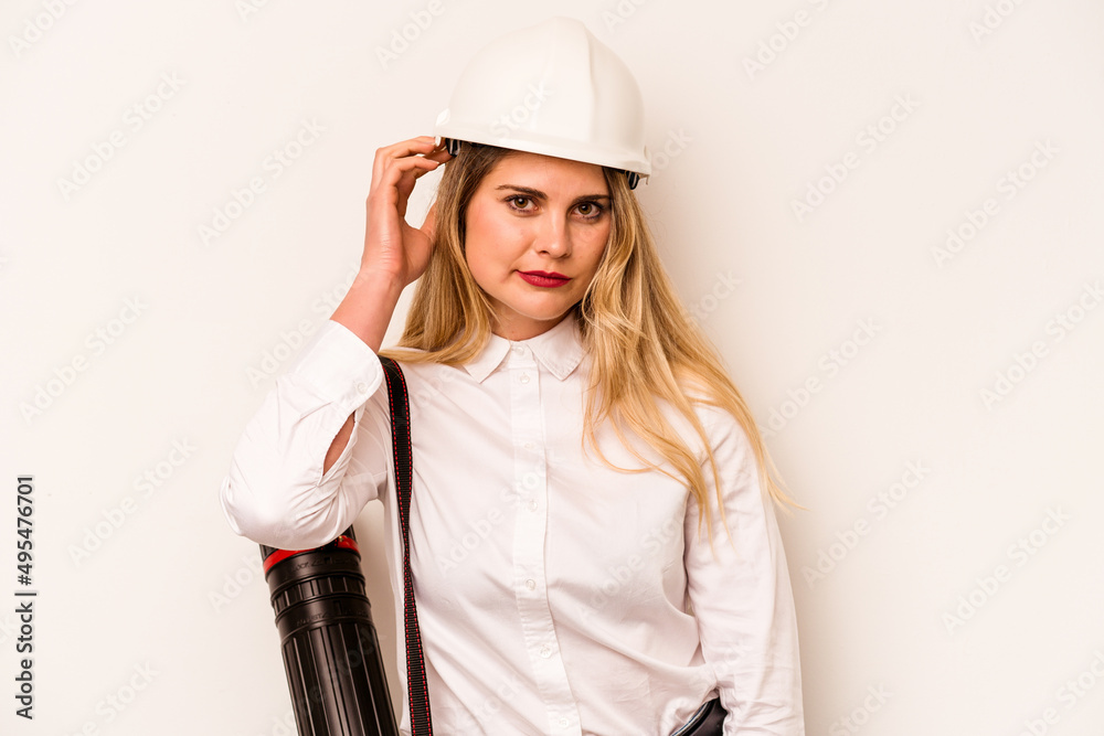 Young architect woman with helmet and holding blueprints isolated on white background being shocked, she has remembered important meeting. Young architect woman with helmet and holding blueprints isolated on white background being shocked, she has remembered important meeting.
