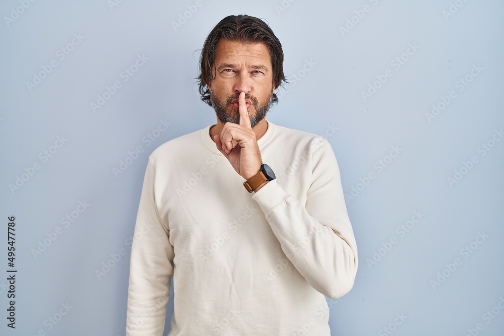 Handsome middle age man wearing casual sweater over blue background asking to be quiet with finger on lips. silence and secret concept. Handsome middle age man wearing casual sweater over blue background asking to be quiet with finger on lips. silence and secret concept.