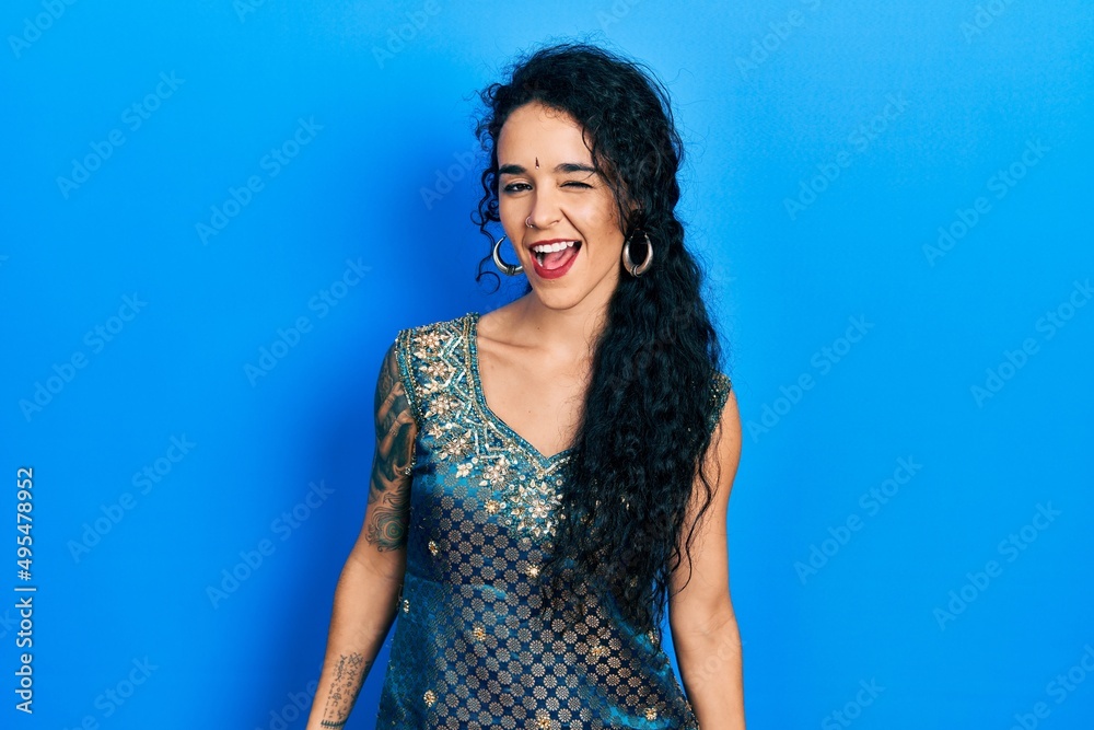 Young woman wearing bindi and traditional kurta dress winking looking at the camera with sexy expression, cheerful and happy face. Young woman wearing bindi and traditional kurta dress winking looking at the camera with sexy expression, cheerful and happy face.
