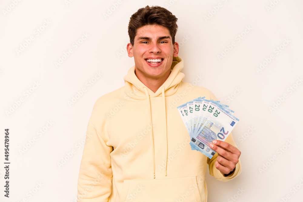 Young caucasian man holding banknotes isolated on white background happy, smiling and cheerful. Young caucasian man holding banknotes isolated on white background happy, smiling and cheerful.