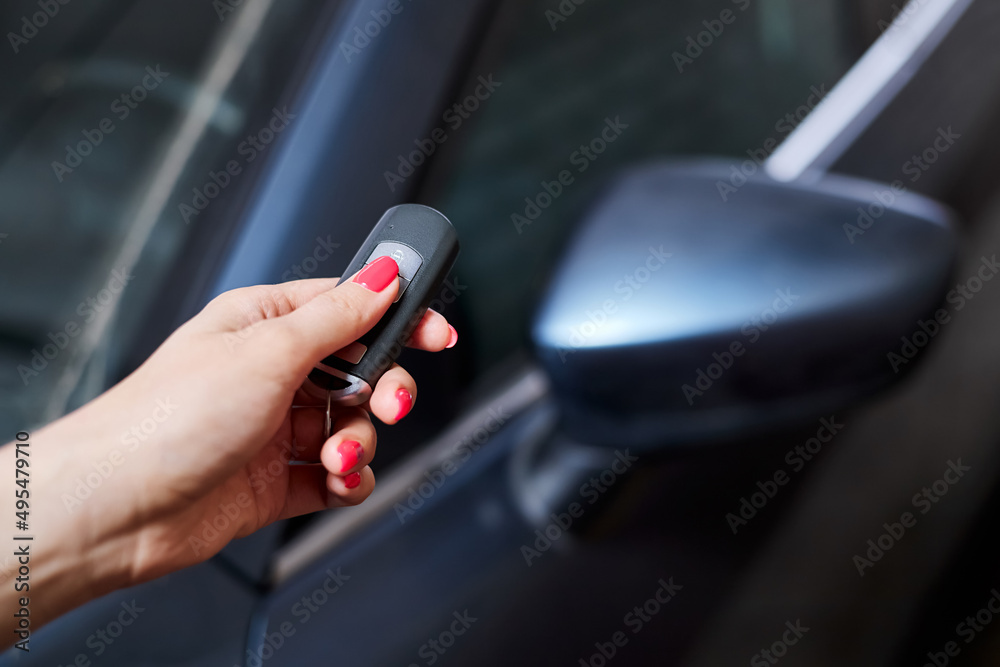 The car owner holds in his hand a remote control device for keyless entry. Close-up, selective focus
