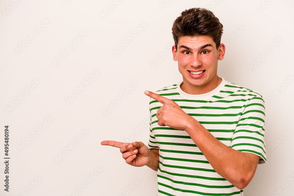 Young caucasian man isolated on white background shocked pointing with index fingers to a copy space. Young caucasian man isolated on white background shocked pointing with index fingers to a copy space.