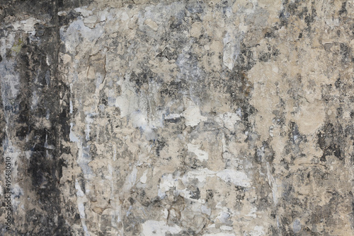 An old and dirty plaster wall texture. A weathered and damaged beige painted wall background.