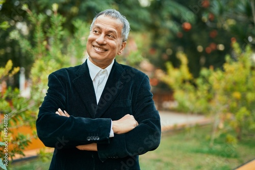 Middle age southeast asian man smiling confident with crossed arms by the park