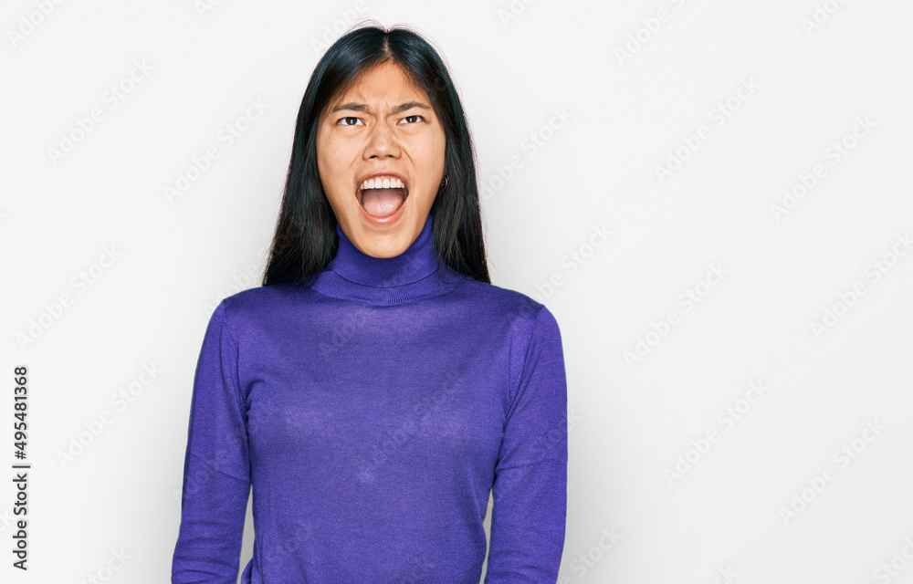Fototapeta premium Beautiful young asian woman wearing casual clothes angry and mad screaming frustrated and furious, shouting with anger. rage and aggressive concept.