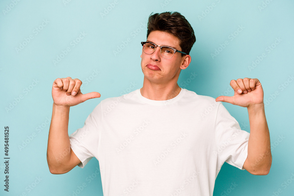 Young caucasian man isolated on blue background feels proud and self confident, example to follow. Young caucasian man isolated on blue background feels proud and self confident, example to follow.