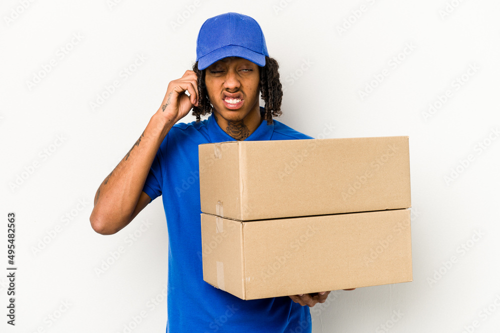 Young African American delivery man isolated on white background covering ears with hands. Young African American delivery man isolated on white background covering ears with hands.