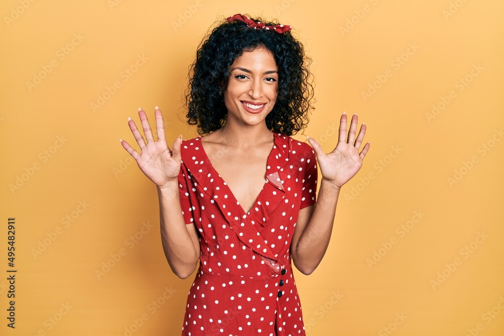 Young latin girl wearing summer dress showing and pointing up with fingers number ten while smiling confident and happy. Young latin girl wearing summer dress showing and pointing up with fingers number ten while smiling confident and happy.
