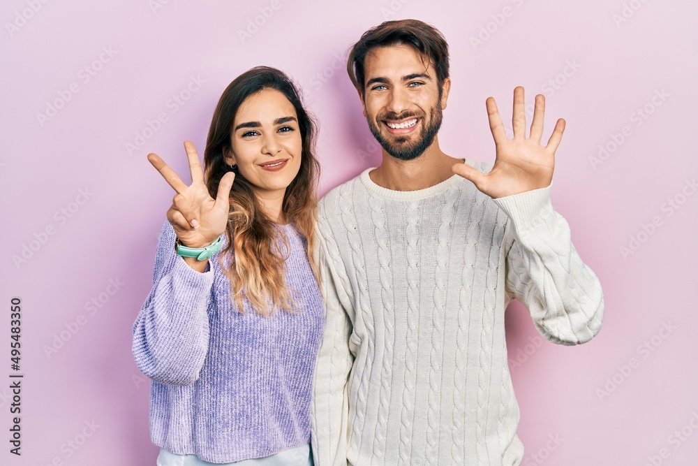 Young hispanic couple wearing casual clothes showing and pointing up with fingers number eight while smiling confident and happy. Young hispanic couple wearing casual clothes showing and pointing up with fingers number eight while smiling confident and happy.
