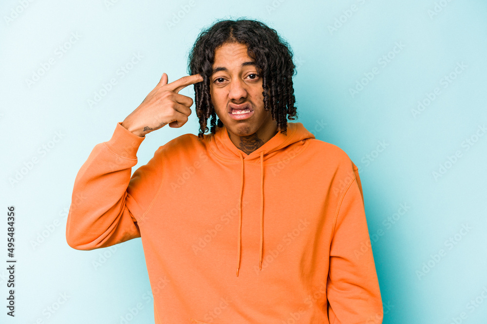 Fototapeta premium Young African American man isolated on blue background covering ears with hands.