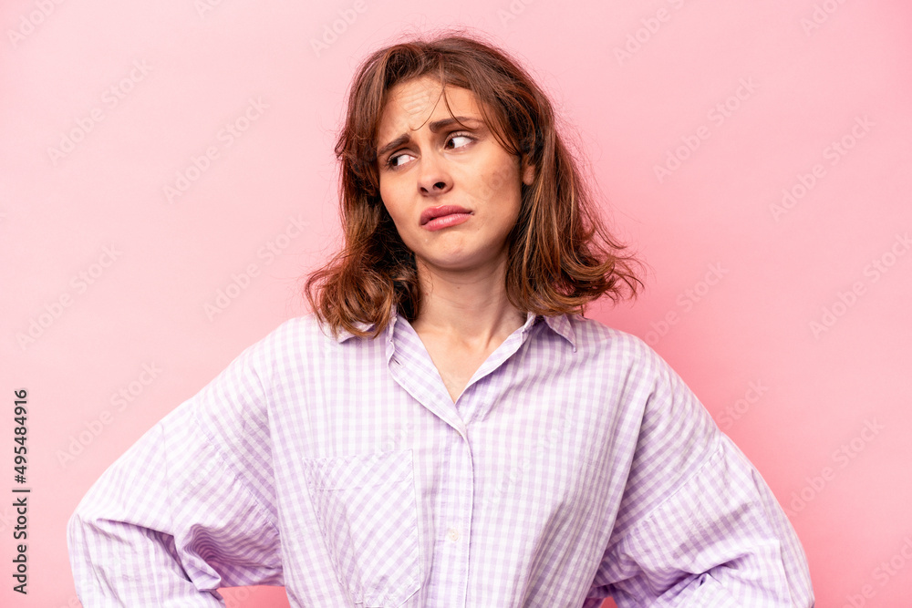 Young caucasian woman isolated on pink background confused, feels doubtful and unsure. Young caucasian woman isolated on pink background confused, feels doubtful and unsure.