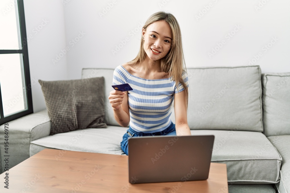 Young chinese woman smiling confident using laptop and credit card at home Young chinese woman smiling confident using laptop and credit card at home