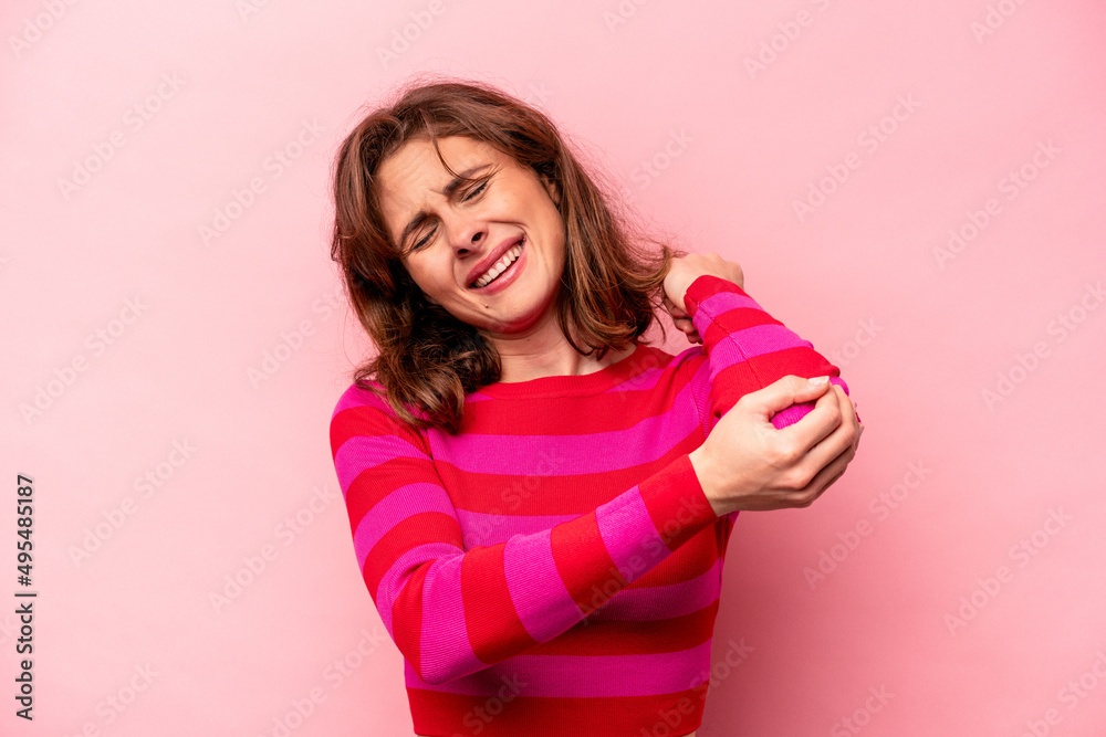 Young caucasian woman isolated on pink background massaging elbow, suffering after a bad movement. Young caucasian woman isolated on pink background massaging elbow, suffering after a bad movement.