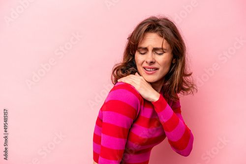 Young caucasian woman isolated on pink background having a shoulder pain.