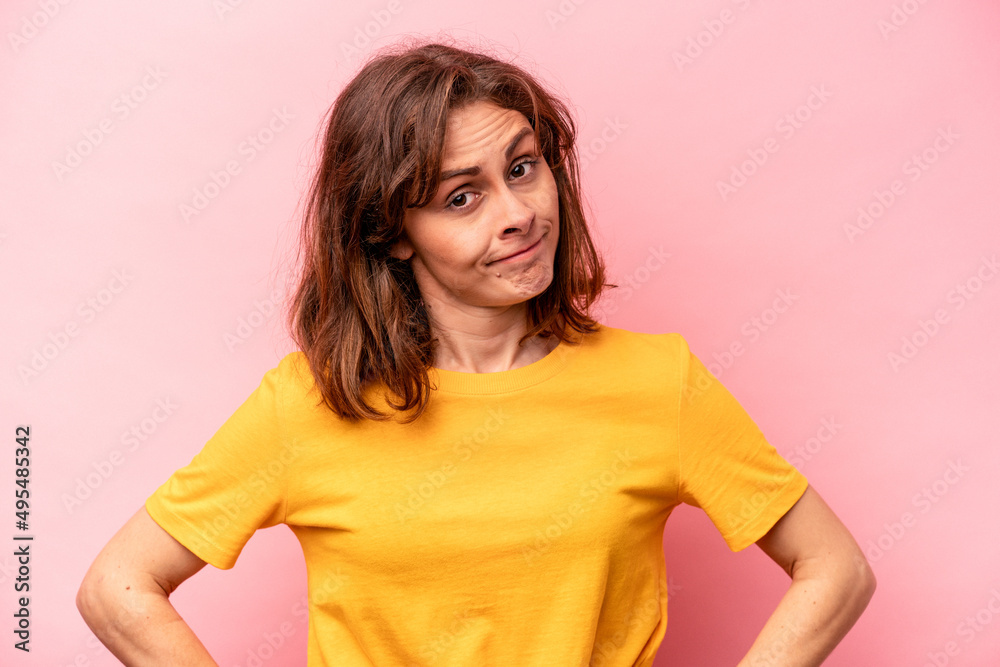 Young caucasian woman isolated on pink background confused, feels doubtful and unsure.