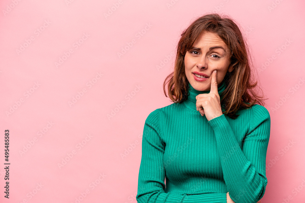 Young caucasian woman isolated on pink background looking sideways with doubtful and skeptical expression. Young caucasian woman isolated on pink background looking sideways with doubtful and skeptical expression.