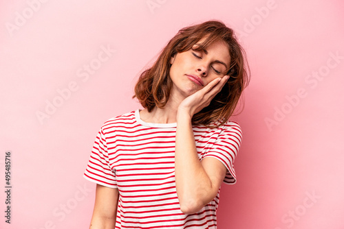 Young caucasian woman isolated on pink background who is bored, fatigued and need a relax day.