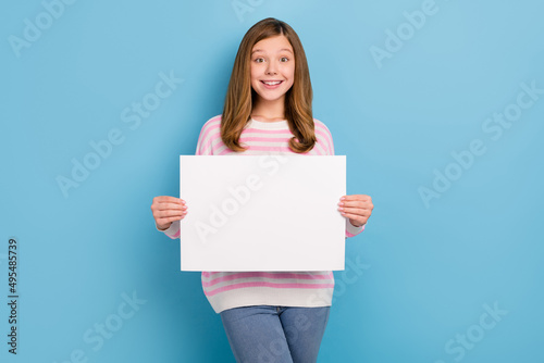 Portrait of cute positive person hands hold empty space list proposition isolated on blue color background