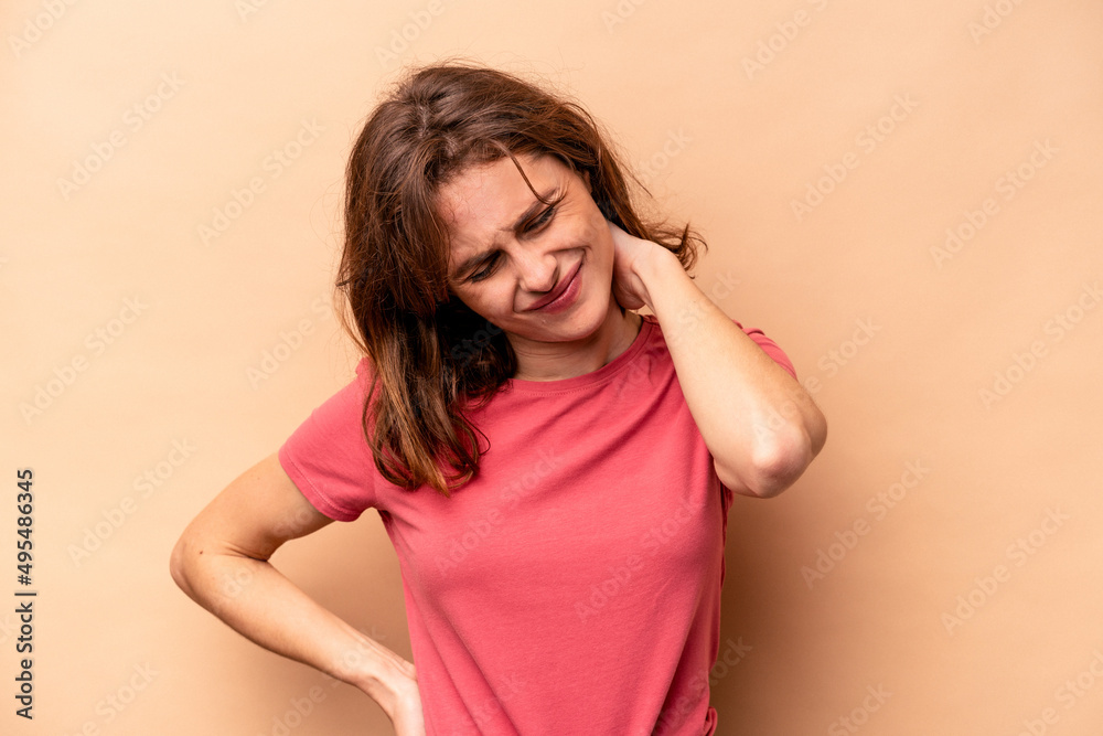 Young caucasian woman isolated on beige background having a neck pain due to stress, massaging and touching it with hand.