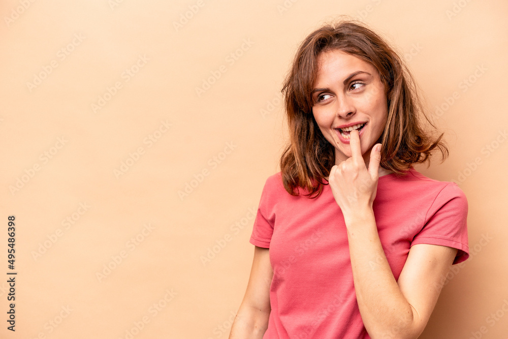 Young caucasian woman isolated on beige background relaxed thinking about something looking at a copy space. Young caucasian woman isolated on beige background relaxed thinking about something looking at a copy space.