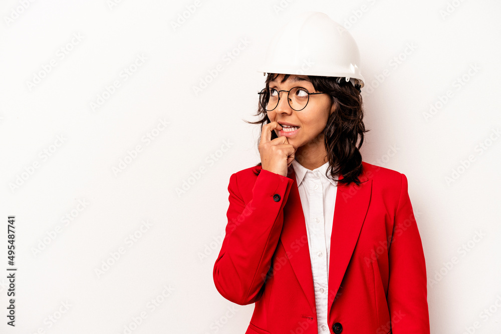 Young architect hispanic woman with helmet isolated on white background relaxed thinking about something looking at a copy space. Young architect hispanic woman with helmet isolated on white background relaxed thinking about something looking at a copy space.