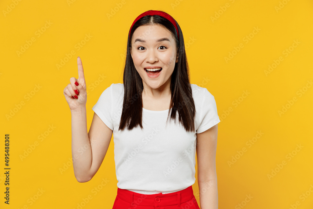 Insighted smart proactive fancy young girl woman of Asian ethnicity 20s years old wears white t-shirt holding index finger up with great new idea isolated on plain yellow background studio portrait. Insighted smart proactive fancy young girl woman of Asian ethnicity 20s years old wears white t-shirt holding index finger up with great new idea isolated on plain yellow background studio portrait.