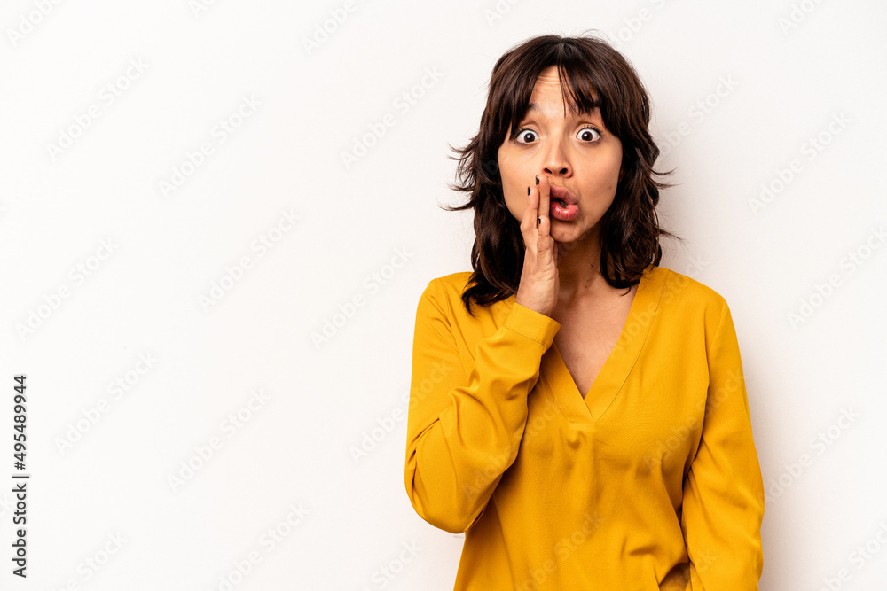 Young hispanic woman isolated on white background is saying a secret hot braking news and looking aside Young hispanic woman isolated on white background is saying a secret hot braking news and looking aside