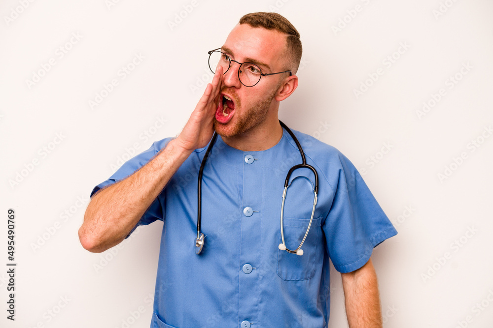 Young caucasian nurse man isolated on white background shouting and holding palm near opened mouth. Young caucasian nurse man isolated on white background shouting and holding palm near opened mouth.