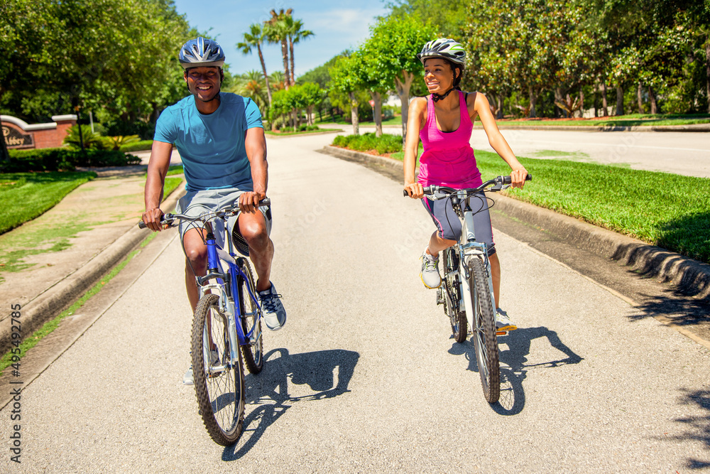 Fototapeta premium Afro American couple in suburban environment riding bikes