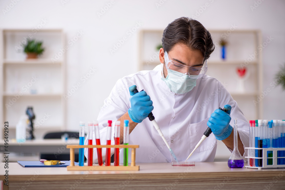 Young male chemist working at the lab Young male chemist working at the lab