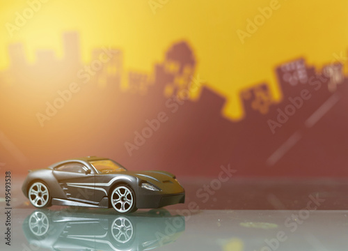 Fototapeta Naklejka Na Ścianę i Meble -  Black Sport car toy selective focus on blur city background
