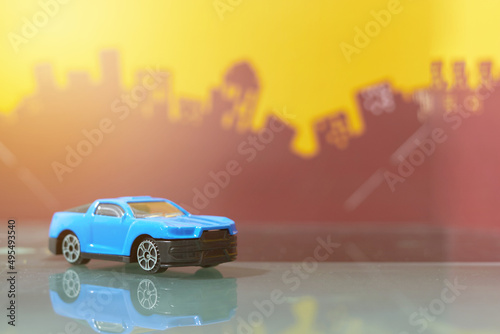 Fototapeta Naklejka Na Ścianę i Meble -  blue muscle car toy selective focus on blur city background