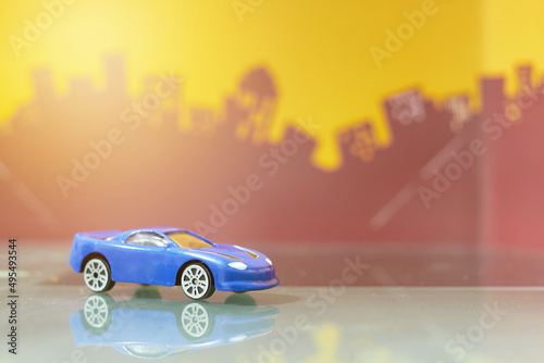 Fototapeta Naklejka Na Ścianę i Meble -  blue Sedan car toy selective focus on blur city background